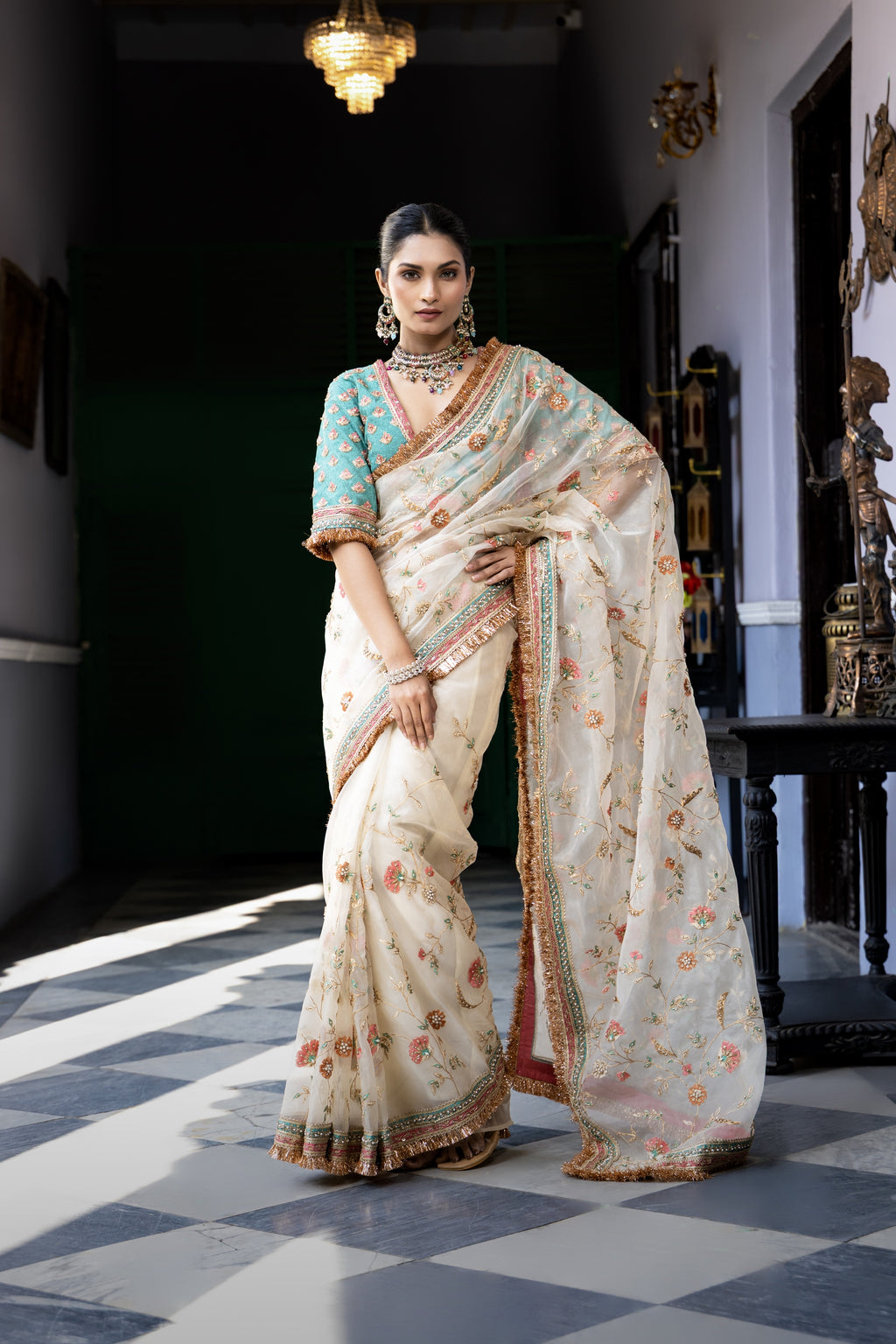Ivory floral embroidered saree with teal blouse and ornate border