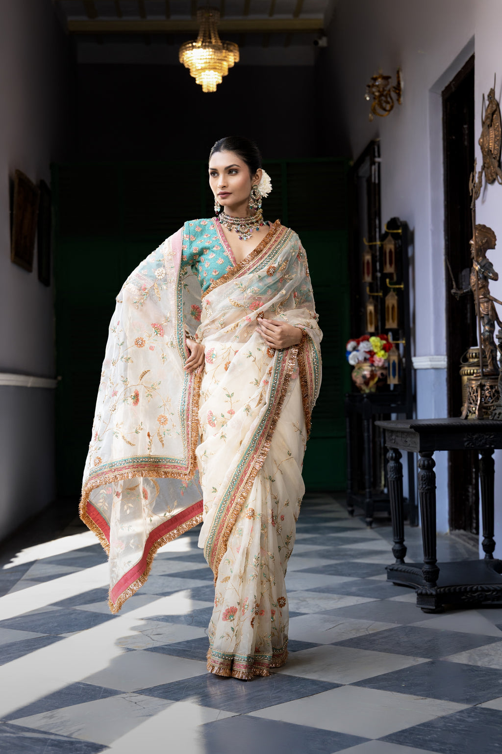 Ivory floral embroidered saree with teal blouse and ornate border