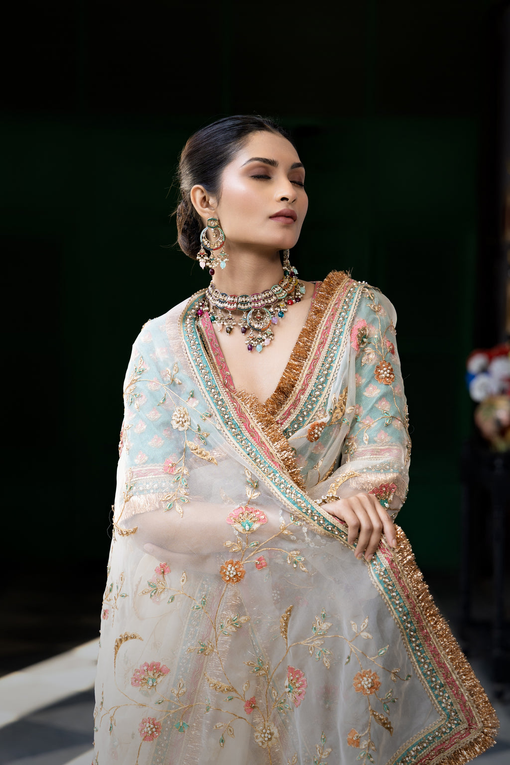 Ivory floral embroidered saree with teal blouse and ornate border