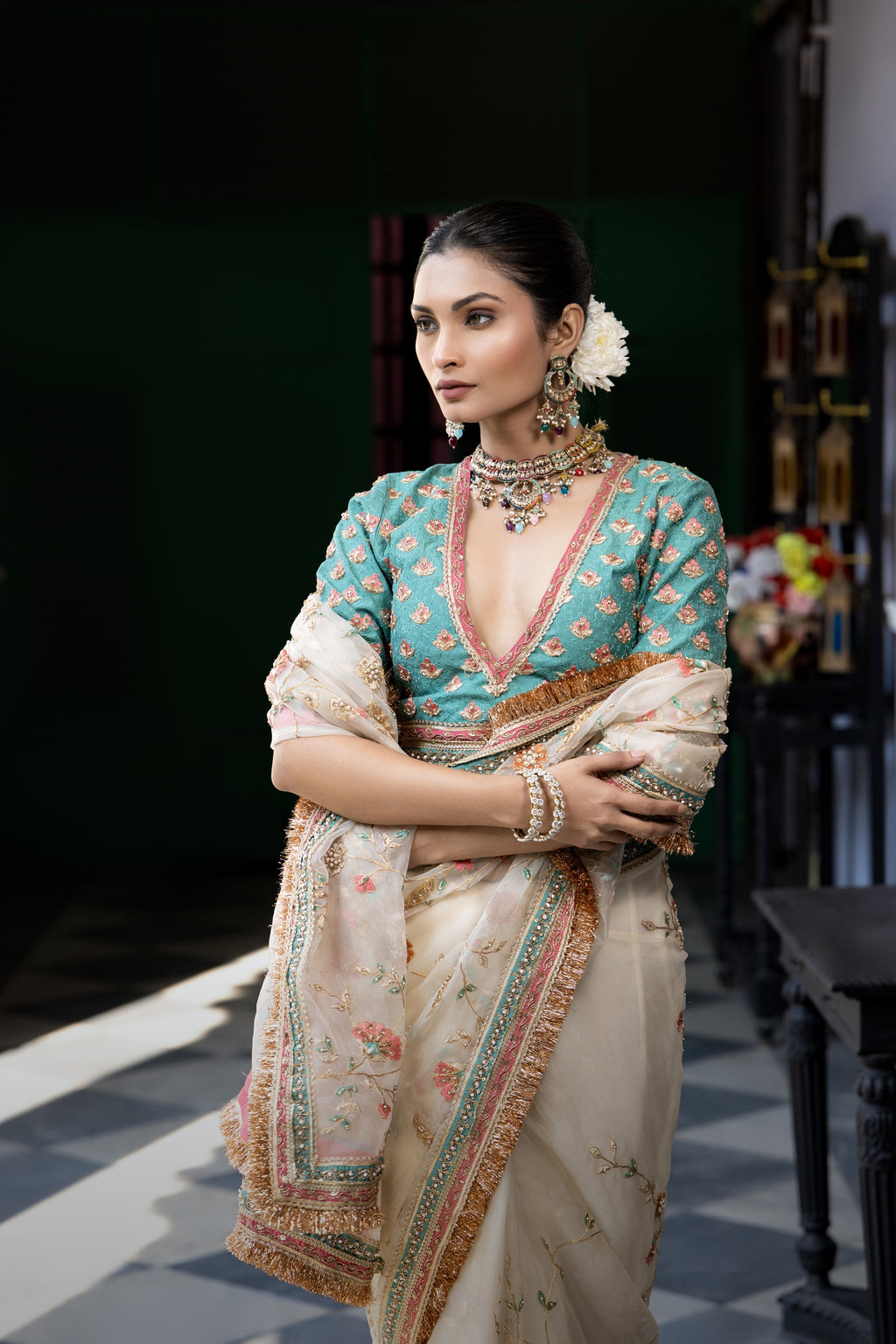 Ivory floral embroidered saree with teal blouse and ornate border