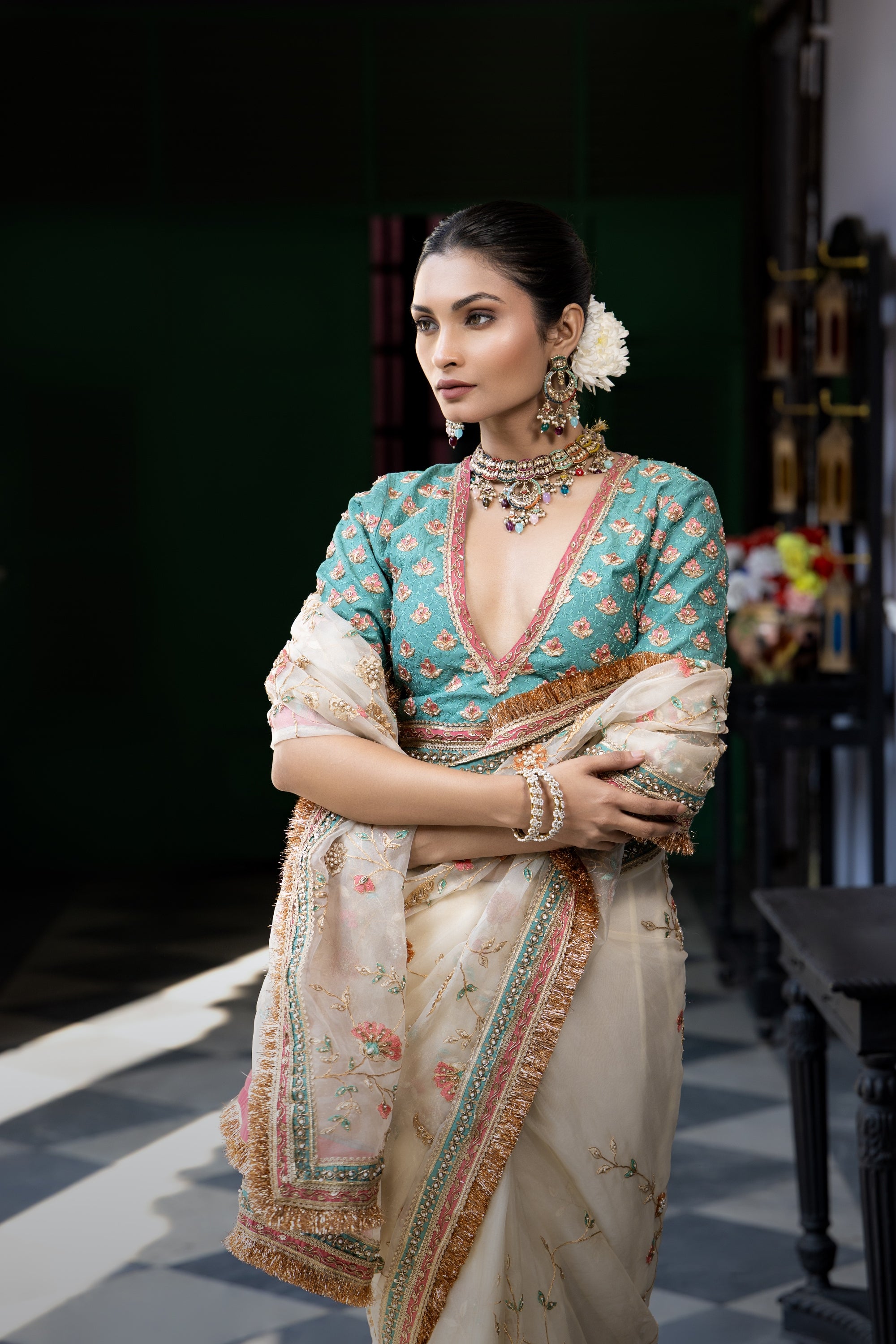 Ivory floral embroidered saree with teal blouse and ornate border